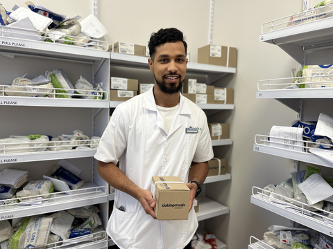 original A pharmacist at Clicks Kabega Park in Gqeberha, South Africa, holds a Dablapmeds medicine parcel. Dablapmeds helps eligible patients collect repeat chronic medicines from convenient community Pick-up Points, including private pharmacies.