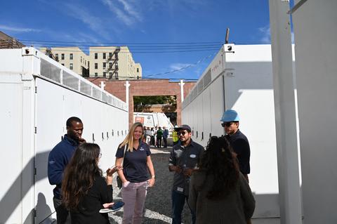 thumbnail Team members and guests at NineDot’s Hunts Point battery storage site, across the street from a NYC Sanitation Dept. facility (and truck) in background.