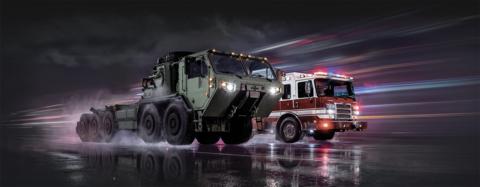 Oshkosh Defense vehicle alongside a Pierce firetruck demonstrating how commercial speed delivers defense consequence.