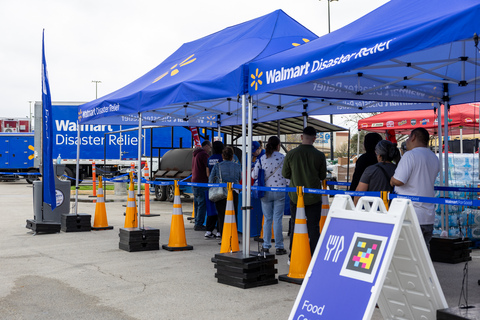 Walmart distributes essential supplies to community members during a disaster relief event in a store parking lot.