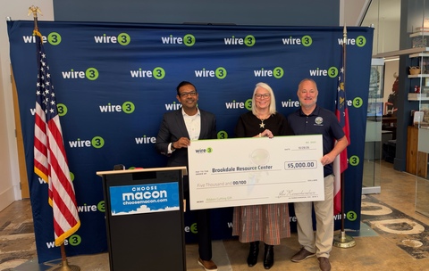 original Wire 3 CEO Jai Ramachandran presents a donation to Alison Bender, executive director of the Brookdale Resource Center, alongside City of Macon Mayor Lester Miller.