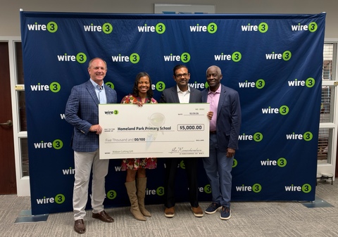 original Wire 3 CEO Jai Ramachandran presents Nicole Torbert-Moorer, Homeland Park Primary School Principal, with donation alongside Mayor Terence Roberts and Councilman Chris Sullivan.